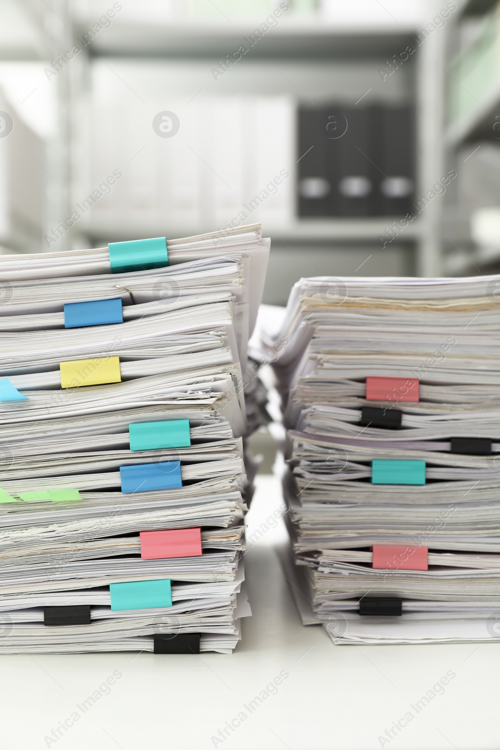 Photo of Stacks of documents with paper clips on office desk