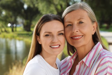 Photo of Family portrait of happy mother and daughter outdoors