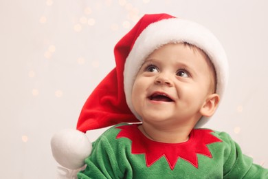 Photo of Cute baby in Christmas costume against blurred lights