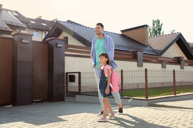 Photo of Happy father taking his little child to school on street