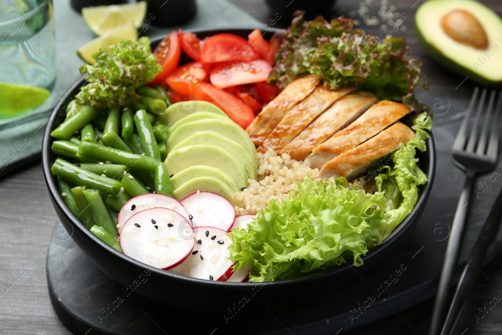 Photo of Healthy meal. Tasty products in bowl on black wooden table, closeup