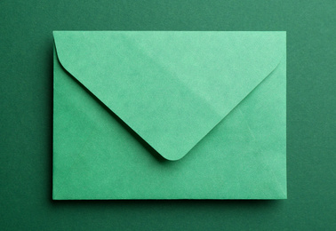 Photo of Paper envelope on green background, top view