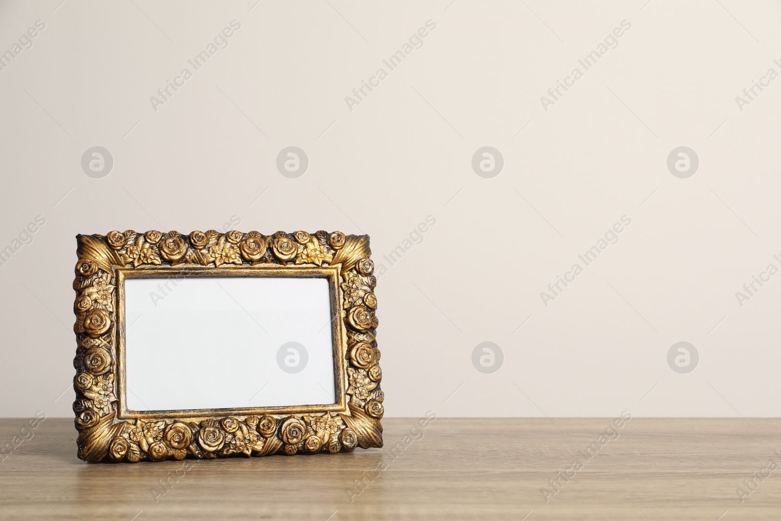 Photo of Beautiful vintage empty frame on wooden table, space for text