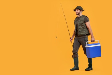 Photo of Fisherman with fishing rod and cool box on yellow background, space for text