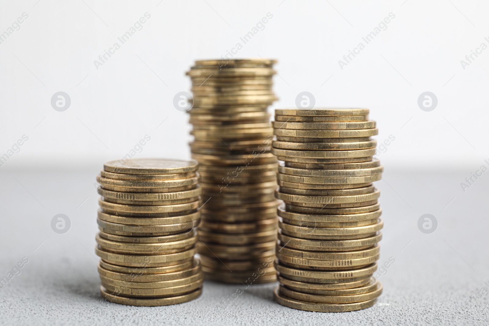 Photo of Many golden coins stacked on white table