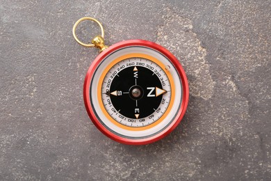 Photo of One compass on grey textured background, top view