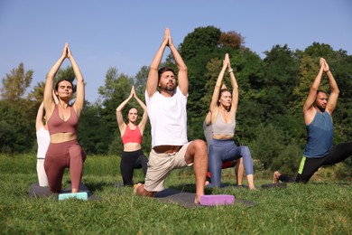 Group of people practicing yoga on mats outdoors