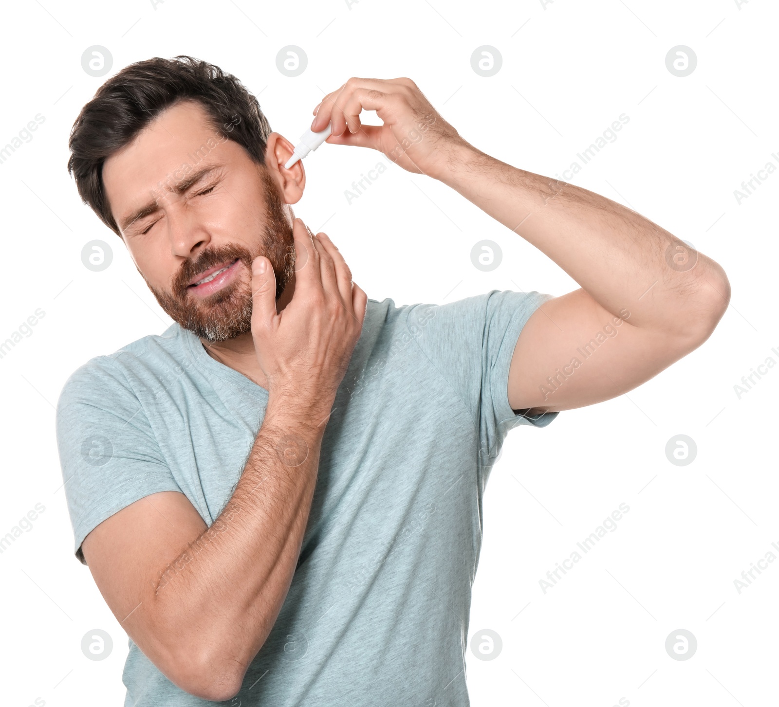 Photo of Man using ear drops on white background