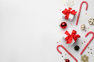 Photo of Flat lay composition with sweet candy canes and Christmas decor, space for text