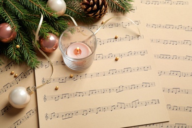 Composition with Christmas decorations on music sheets, above view