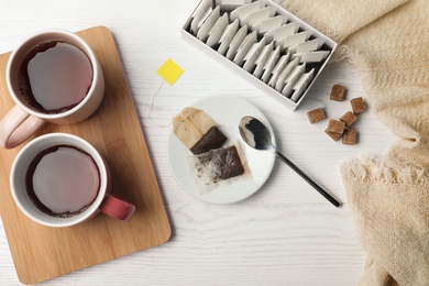 Photo of Flat lay composition with fresh tea and bags on wooden background