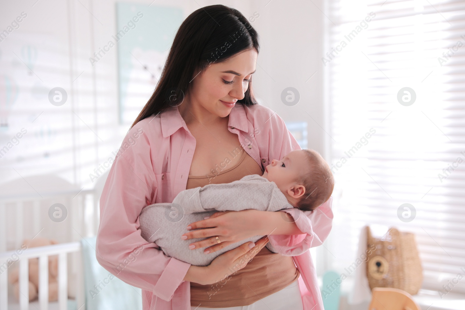 Photo of Young woman with her cute baby at home