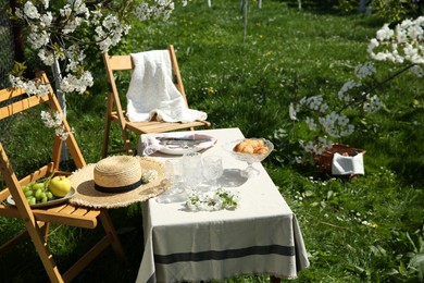 Photo of Beautiful table setting with spring flowers in garden on sunny day