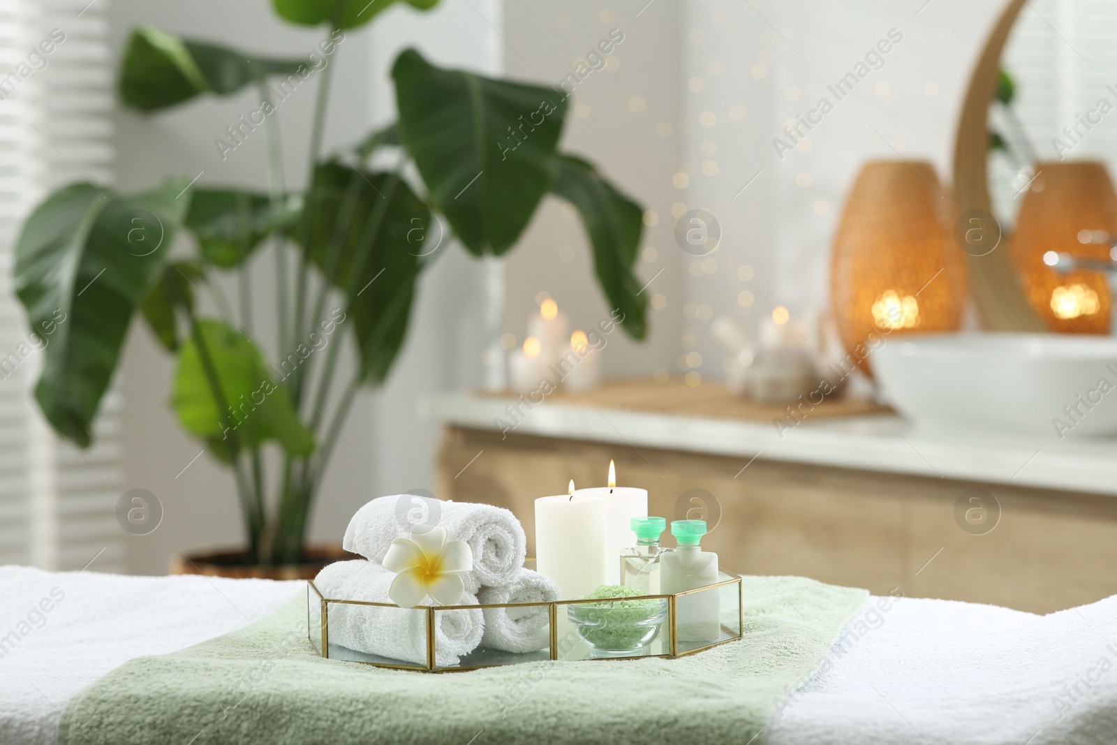 Photo of Composition with different spa products and burning candles on table indoors. Space for text