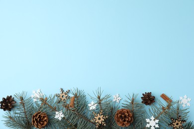Winter composition with fir tree on light blue background, flat lay. Space for text