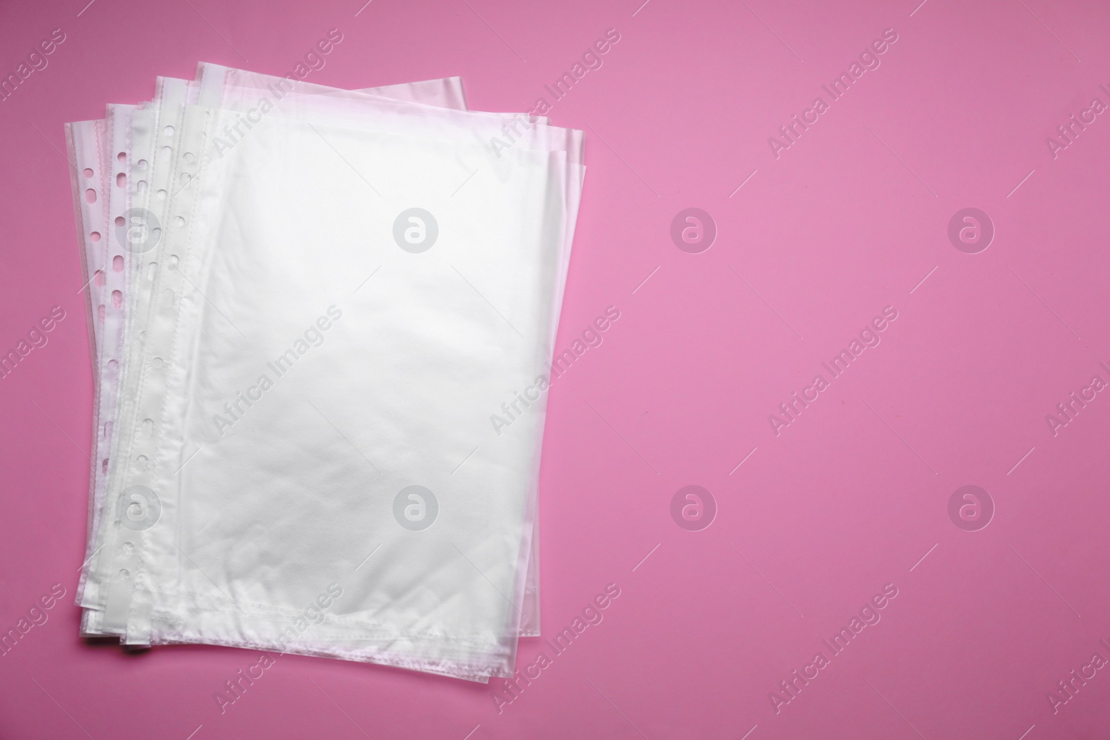 Photo of Punched pockets on pink background, flat lay. Space for text