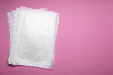 Photo of Punched pockets on pink background, flat lay. Space for text