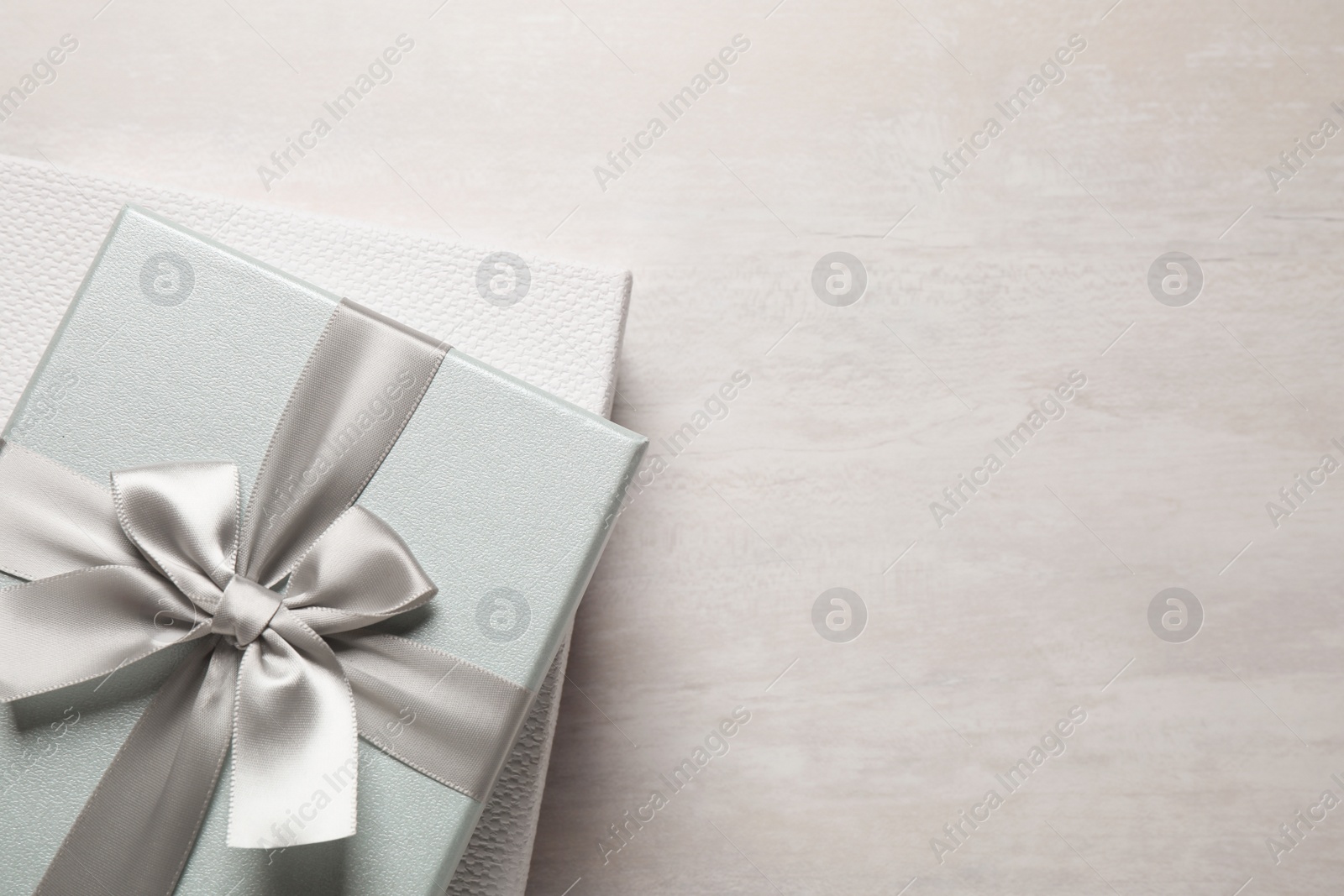 Photo of Elegant gift boxes on white table, top view. Space for text