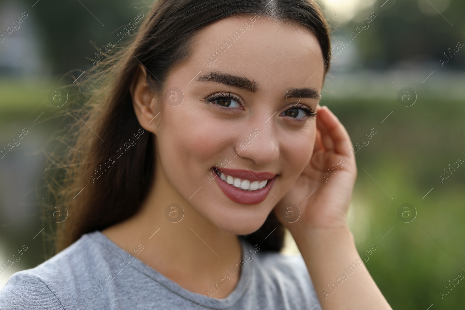 Photo of Portrait of beautiful woman outdoors. Attractive lady smiling and looking into camera