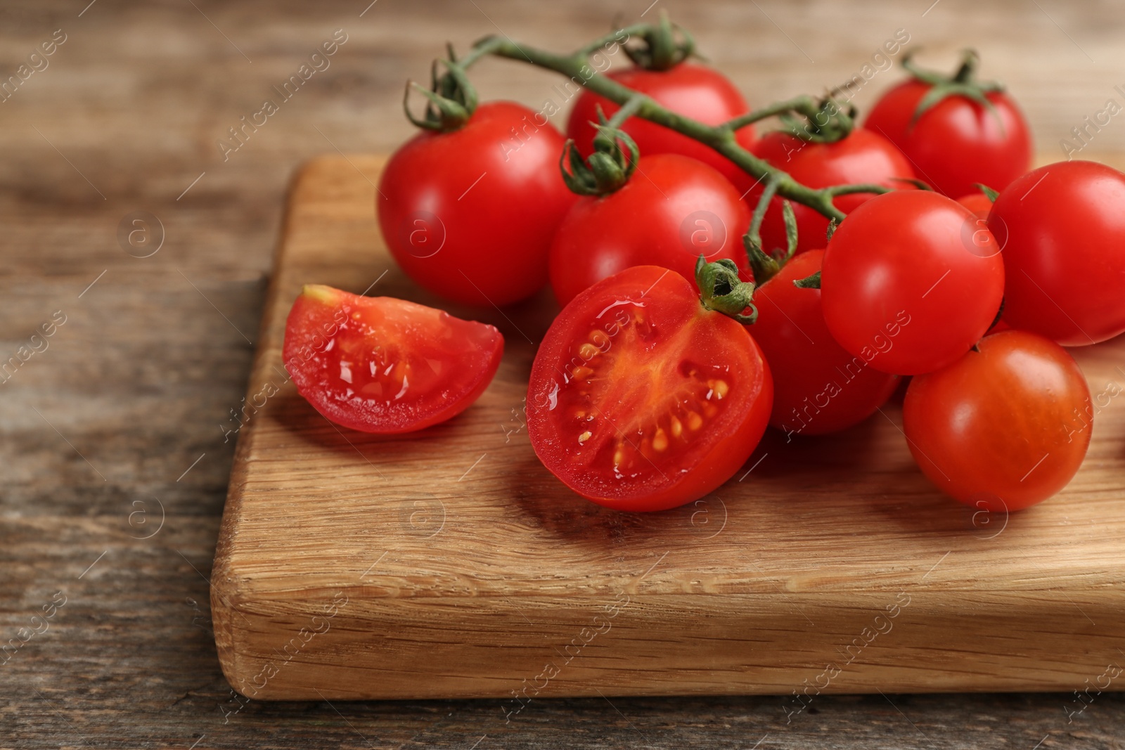 Photo of Fresh ripe cherry tomatoes on wooden table, closeup