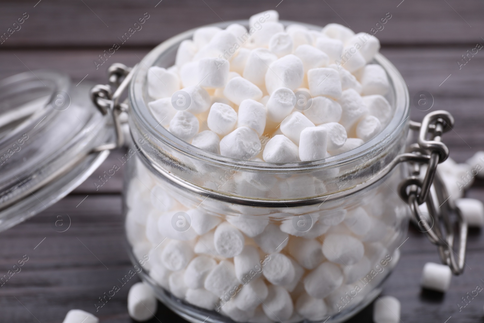 Photo of Glass jar with delicious marshmallows on wooden table, closeup