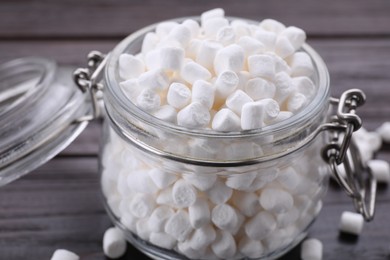 Glass jar with delicious marshmallows on wooden table, closeup