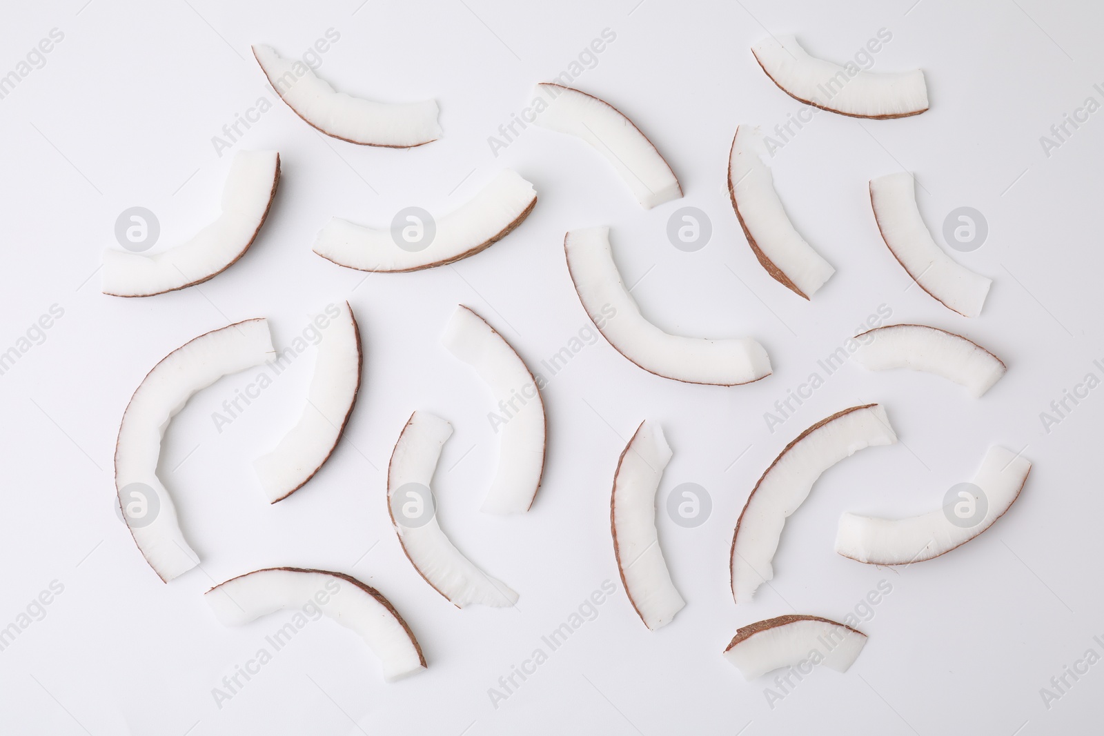 Photo of Pieces of fresh coconut on white background, top view
