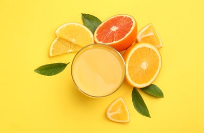 Photo of Delicious orange juice and fresh fruits on yellow background, flat lay