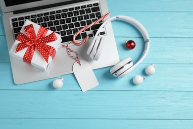 Flat lay composition with headphones on blue wooden background. Christmas music