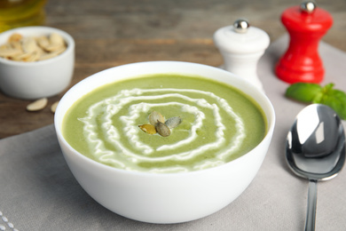 Photo of Delicious broccoli cream soup served on table