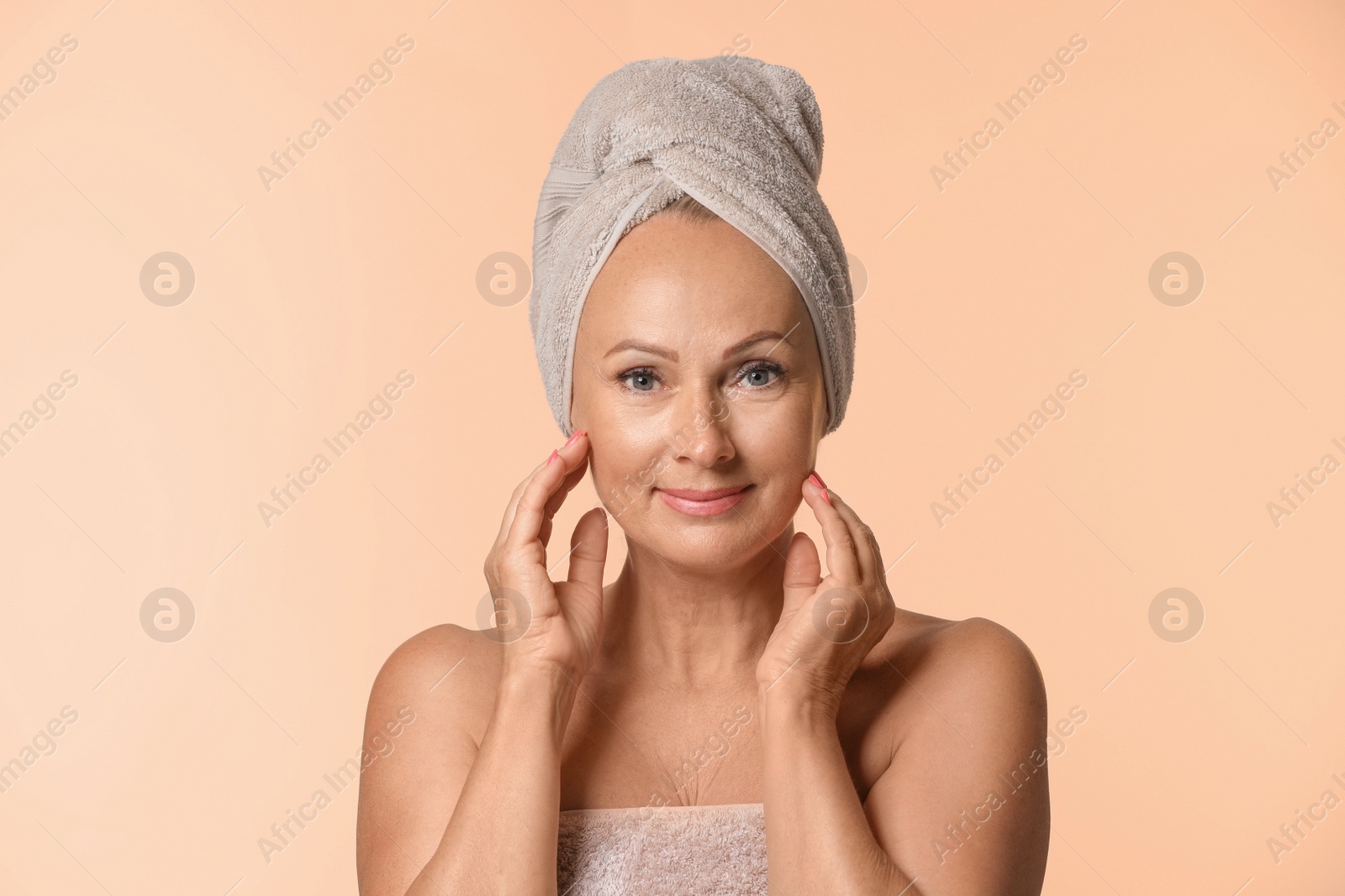 Photo of Portrait of beautiful mature woman with perfect skin on beige background