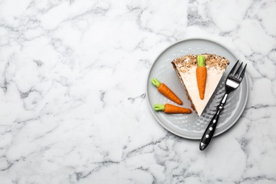 Photo of Plate with sweet carrot cake on white marble table, top view. Space for text