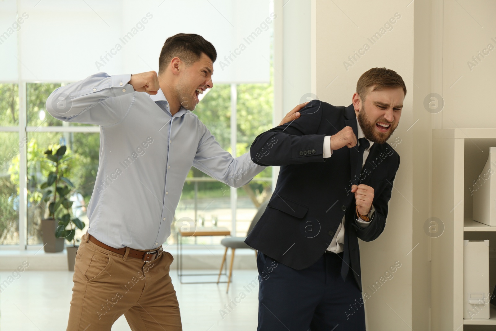 Photo of Emotional colleagues fighting in office. Workplace conflict