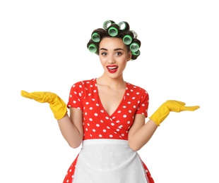 Photo of Funny young housewife with hair rollers and rubber gloves on white background