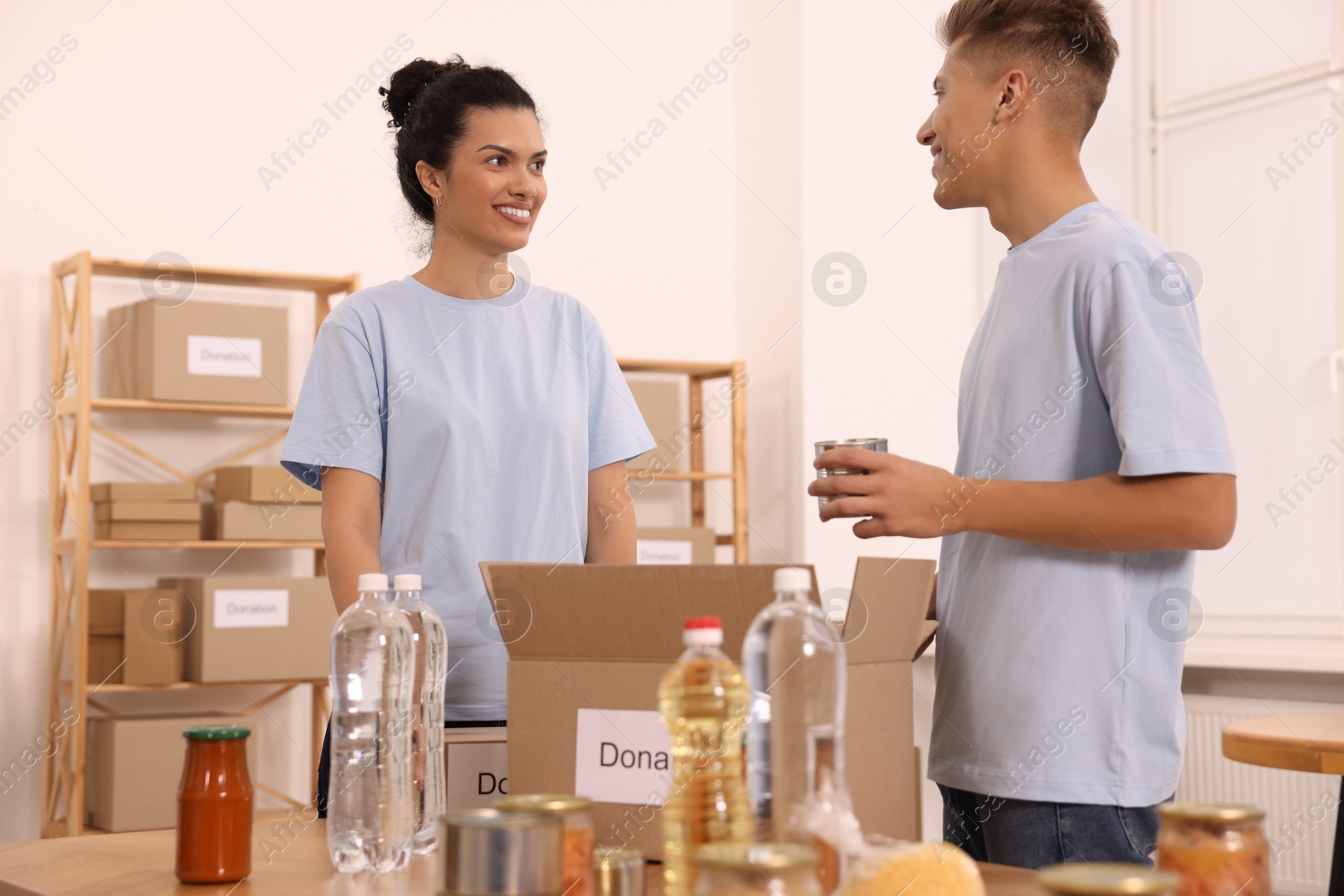 Photo of Volunteers packing food products at table in warehouse