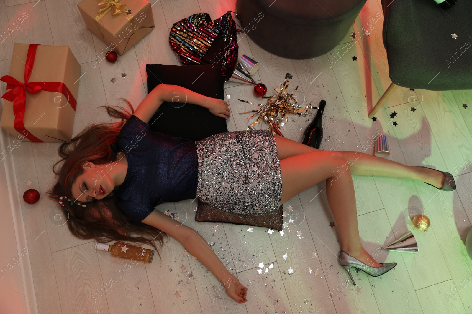 Photo of Drunk woman sleeping on floor in messy room after New Year party, above view