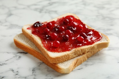 Slice of bread with jam on white marble table