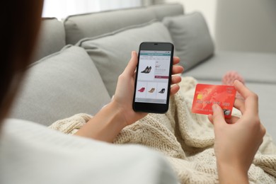 Photo of Woman with credit card using smartphone for online shopping indoors, closeup