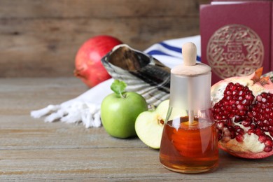 Photo of Honey, pomegranate, apples, shofar and Torah on wooden table. Rosh Hashana holiday