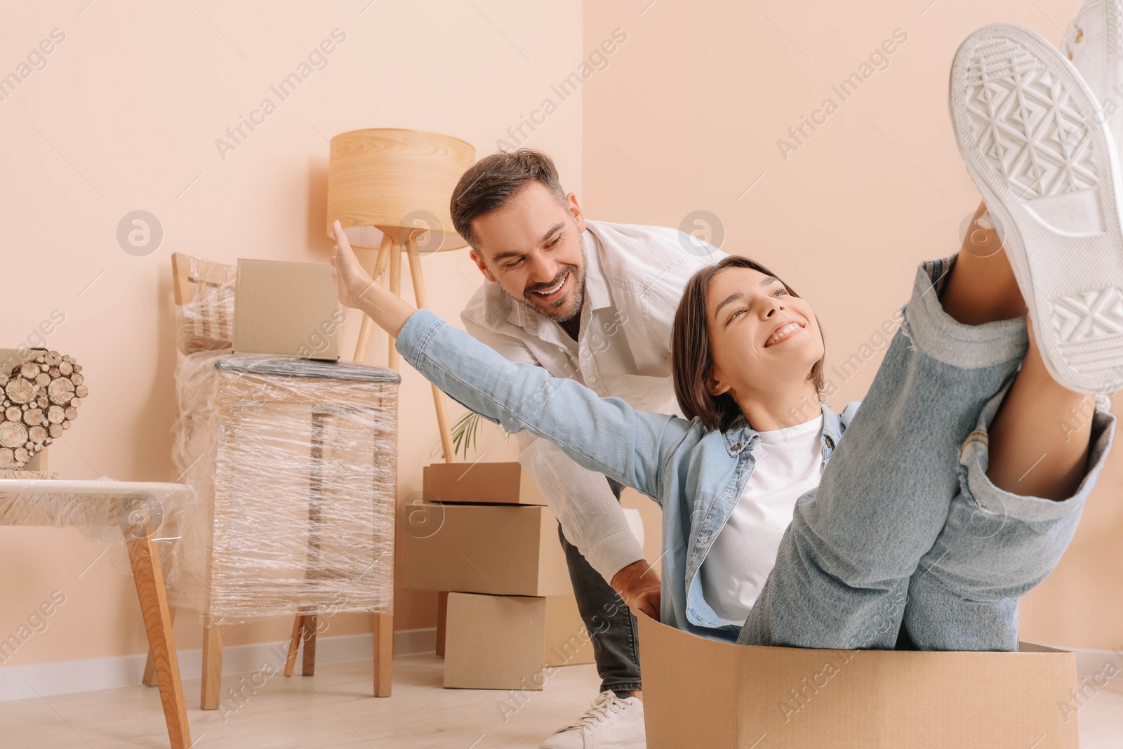 Photo of Happy couple having fun in new apartment. Moving day