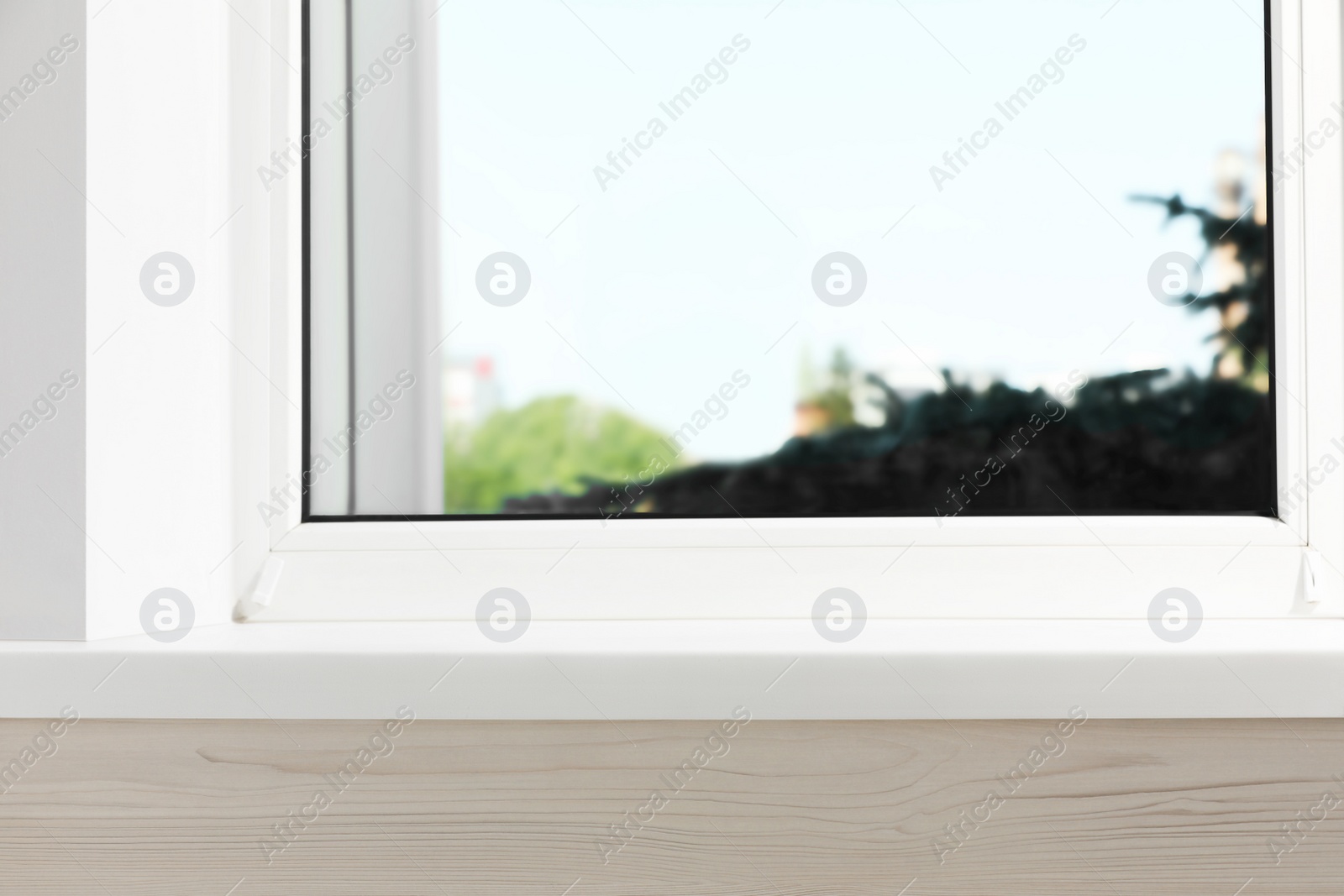 Photo of Empty white window sill and spruce tree outside