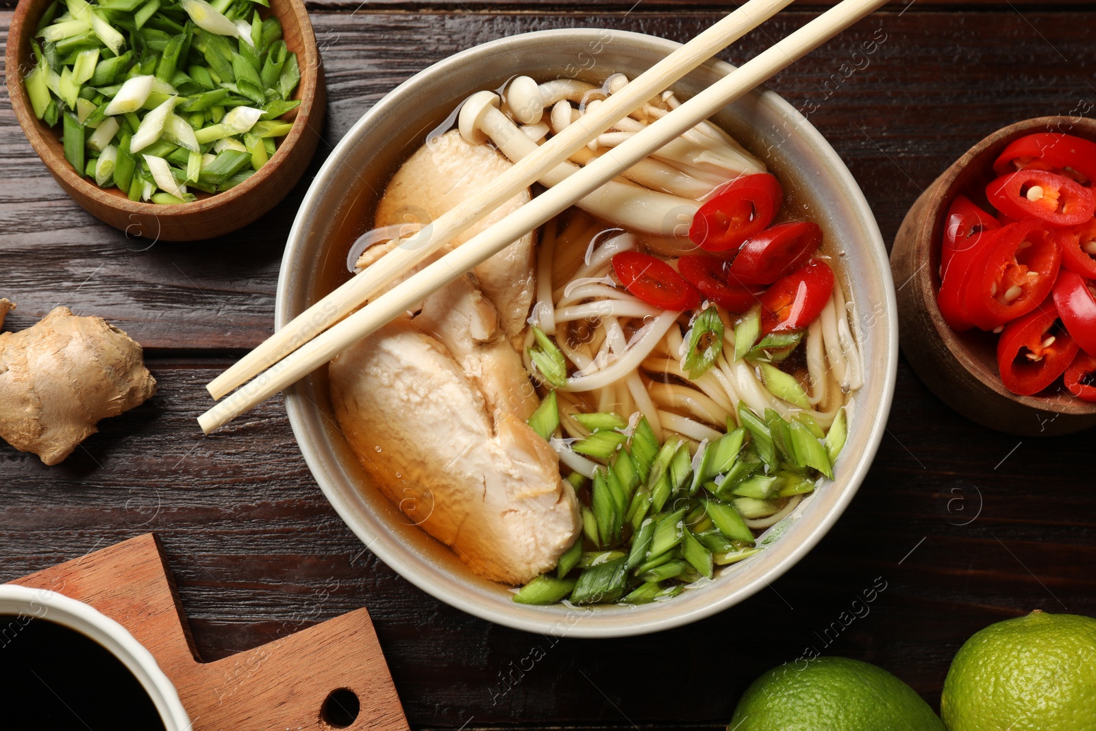 Photo of Delicious ramen with meat and ingredients on wooden table, flat lay. Noodle soup