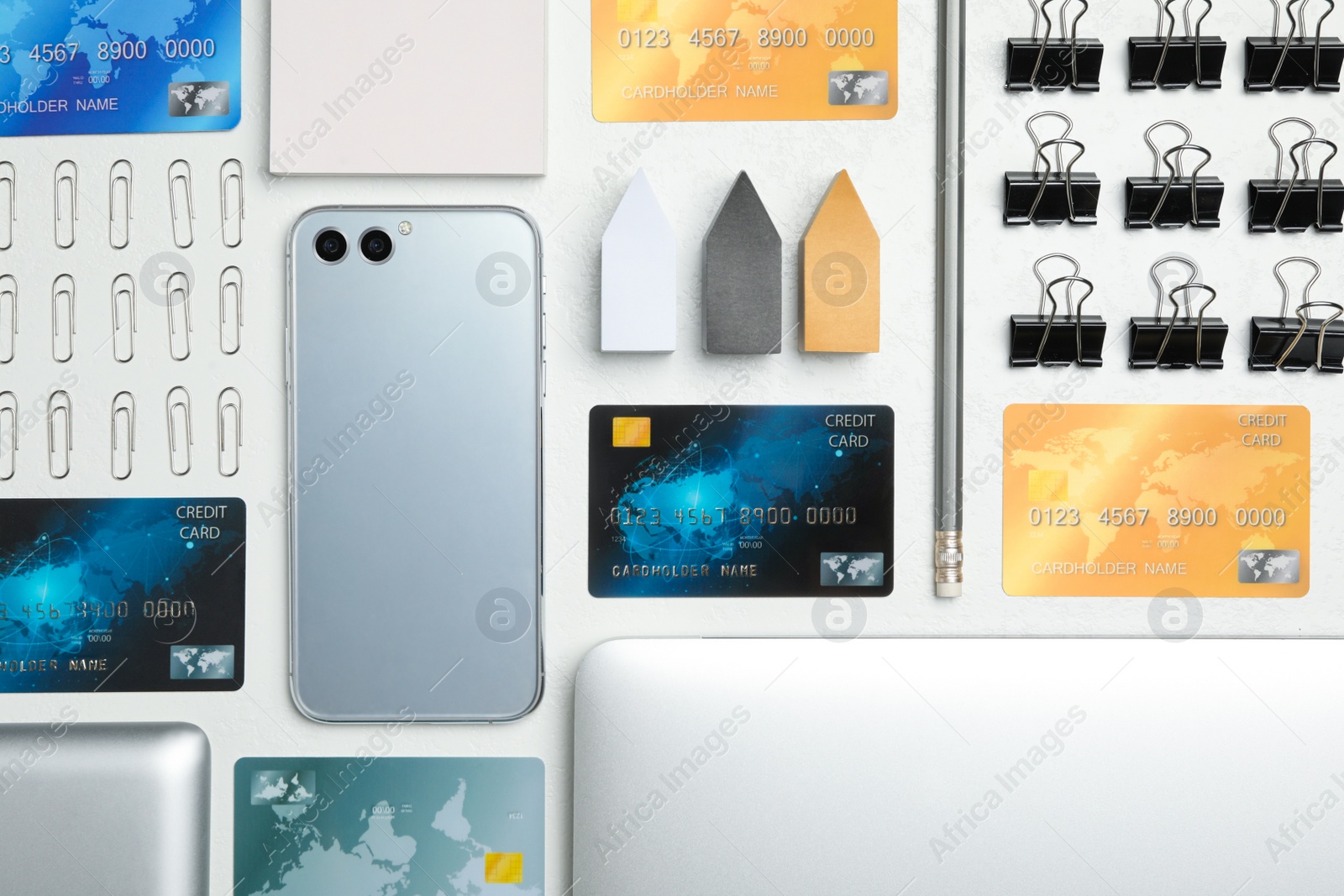 Photo of Flat lay composition with credit cards, smartphone and stationery on white table