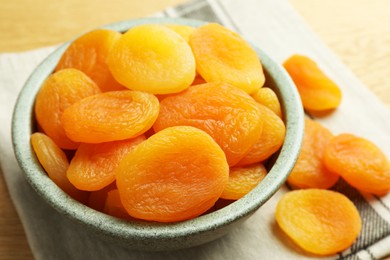 Bowl of tasty apricots on wooden table, closeup. Dried fruits