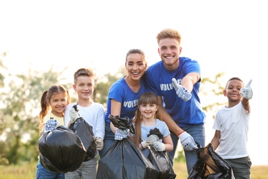 Photo of Volunteers and kids with bags of trash in park