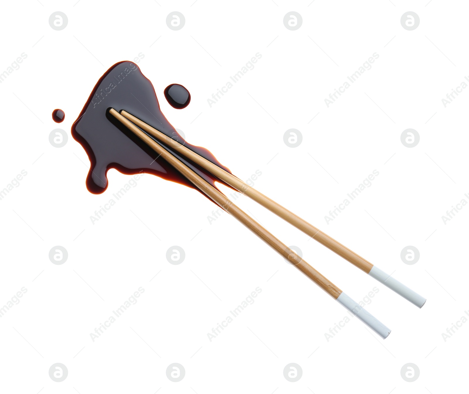 Photo of Spilled soy sauce with chopsticks on white background, top view