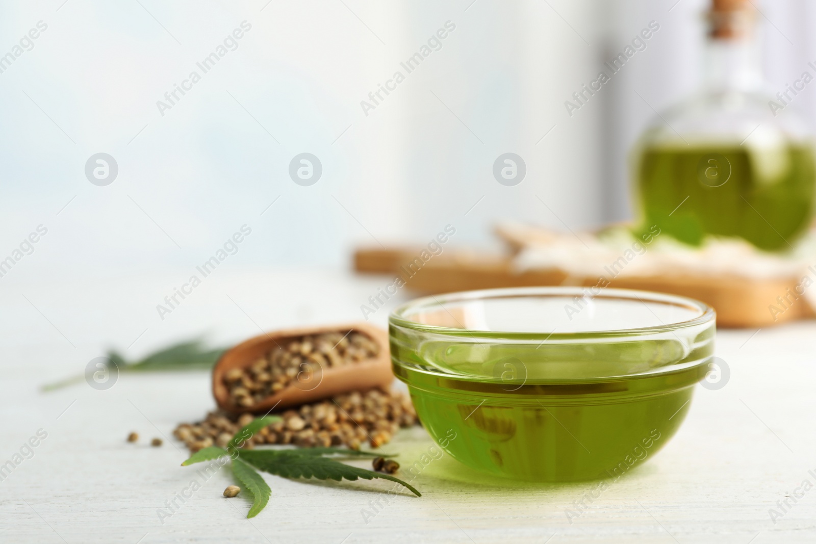 Photo of Composition with hemp oil on white wooden table