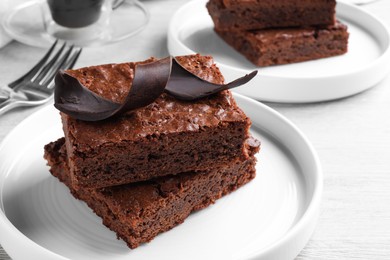 Photo of Delicious chocolate brownies served on white wooden table, closeup