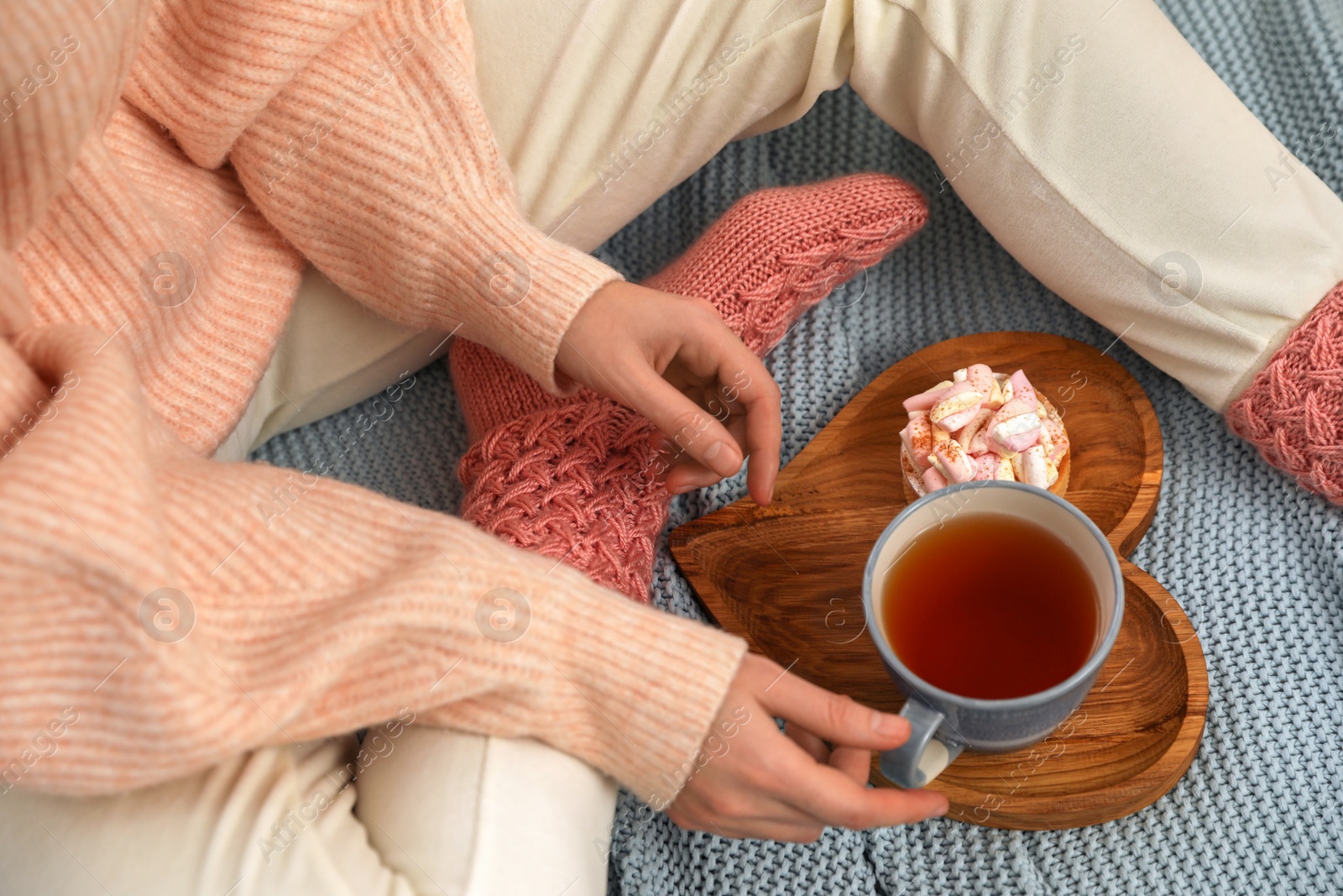 Photo of Woman with tea and snack on plaid, above view