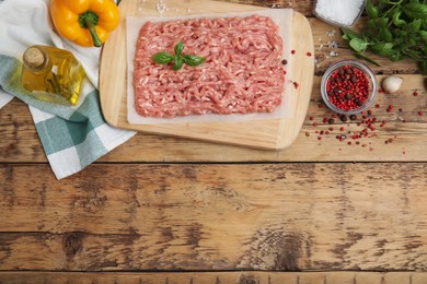 Raw chicken minced meat and ingredients on wooden table, flat lay. Space for text